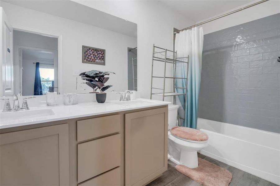 Full bathroom with shower / bath combination with curtain, vanity, wood-type flooring, and toilet