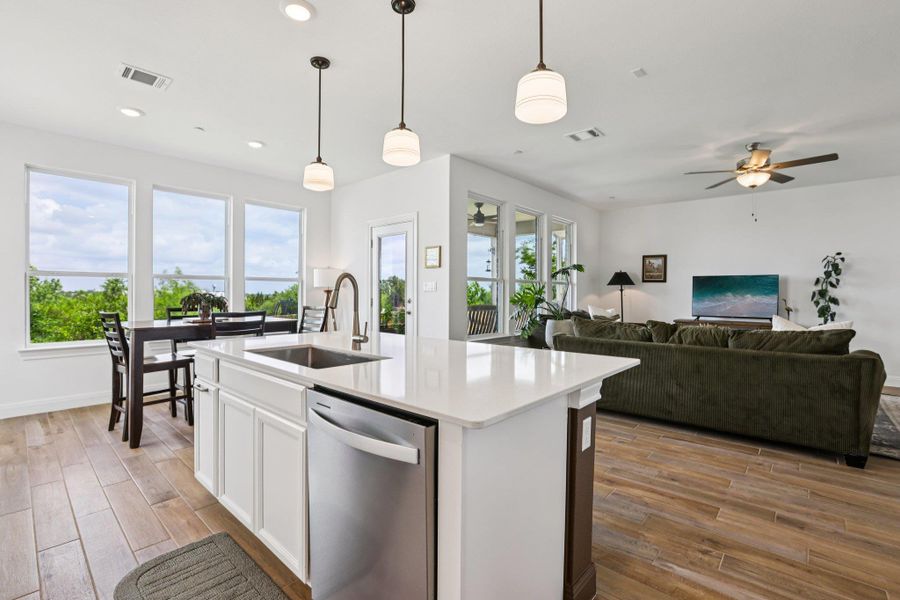 The property features an open concept kitchen and living area with wood-look tile flooring and recessed lighting