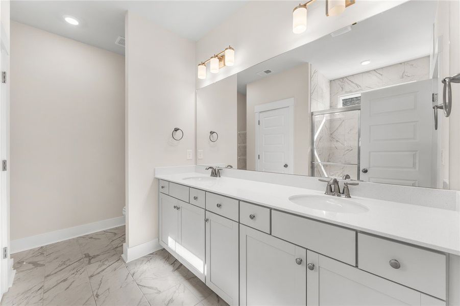 This spacious bathroom features a dual vanity, sle
