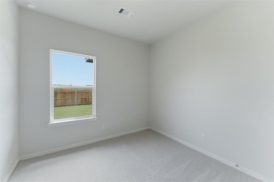 Neutral-toned interior room featuring light gray carpeting and a single window with white trim