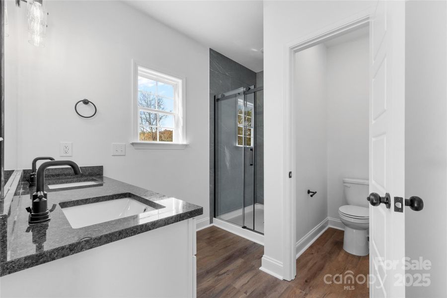 ensuite primary bathroom with tiled shower and private commode room ensuite primary bathroom with tiled shower and private commode room