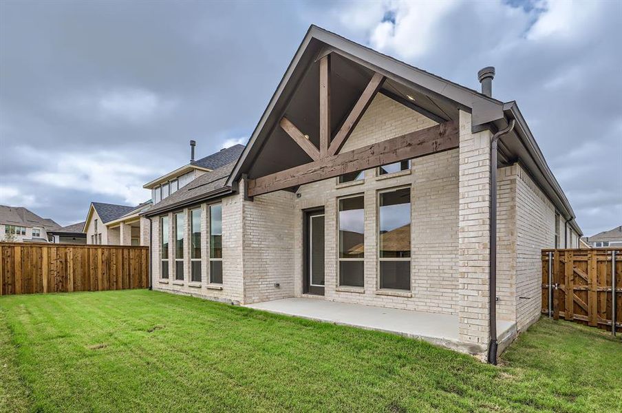 Rear view of property featuring a lawn and a patio area