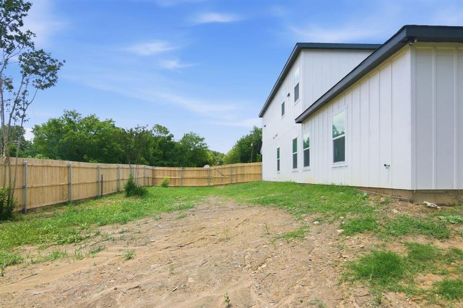 Two-story residence with white board and batten siding, dark trim, and multiple windows