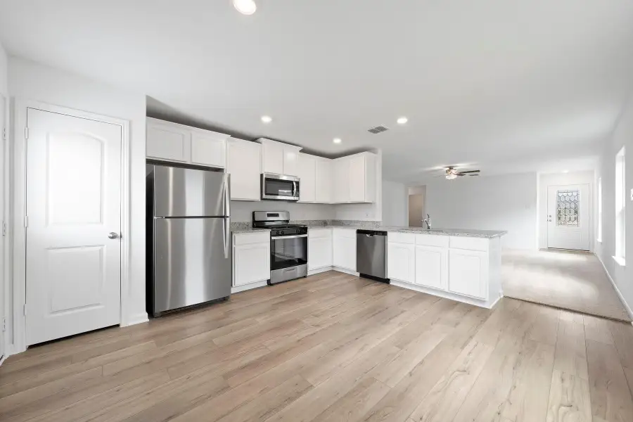 A well-appointed kitchen features stainless steel appliances, abundant cabinetry, and a convenient island with a sink.