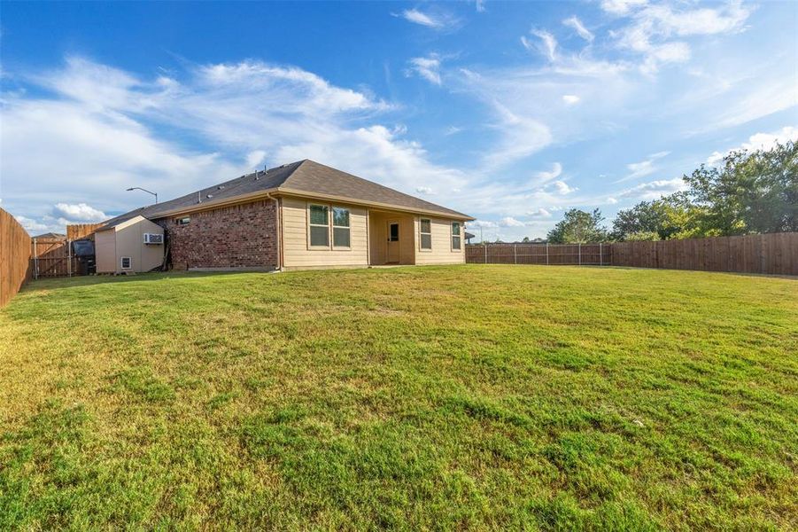 Back of property with a lawn