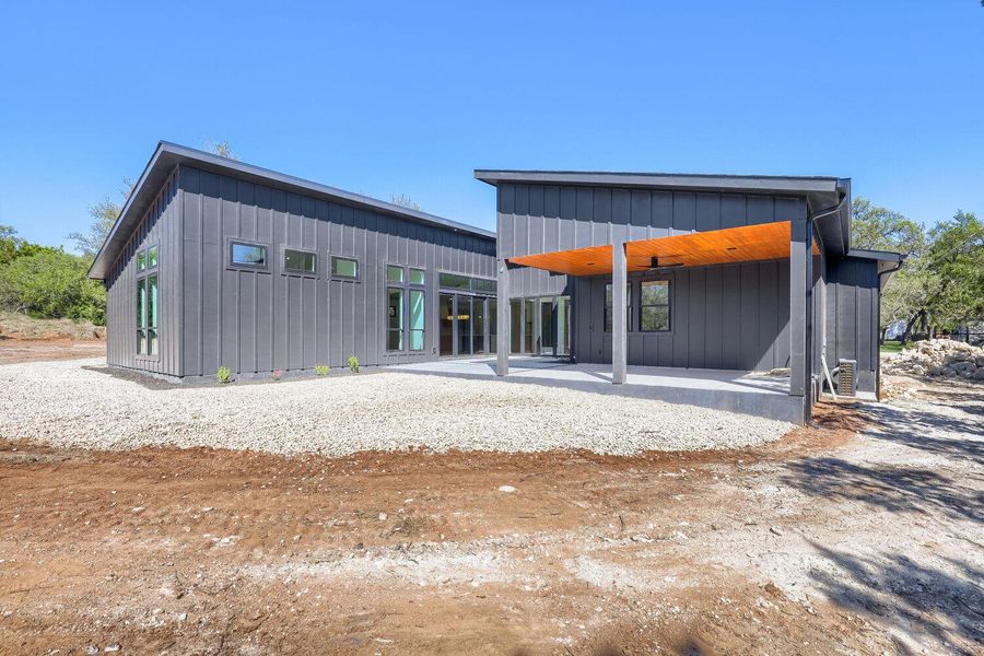 Back of house with a patio area and board and batten siding Back of house with a patio area and board and batten siding