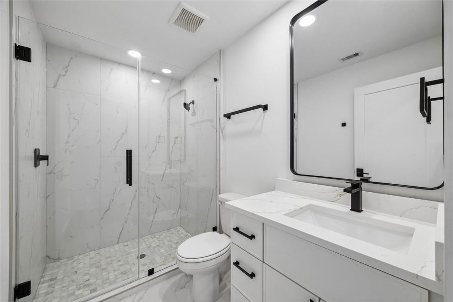 Secondary bathrooms continue the home’s modern architectural approach with sleek plumbing fixtures, quartz surfaces, bright finishes, and clean-lined design details carried throughout the interior spaces.