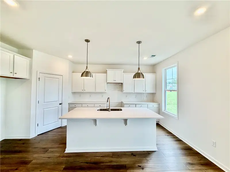 Gleaming stone countertops and rich wood flooring