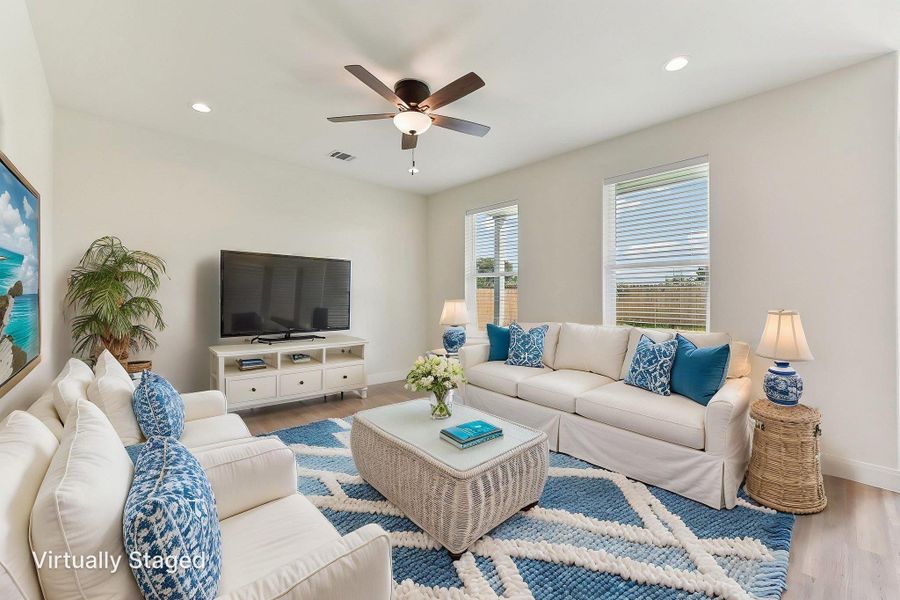 Virtually Staged Living area with wood style floors, visible vents, a ceiling fan, and baseboards