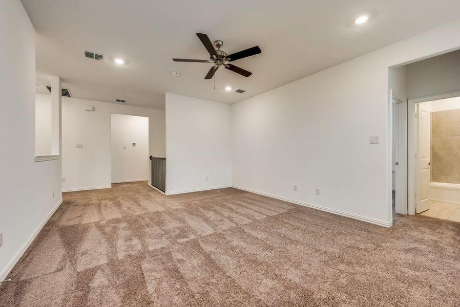 Carpeted empty room featuring ceiling fan