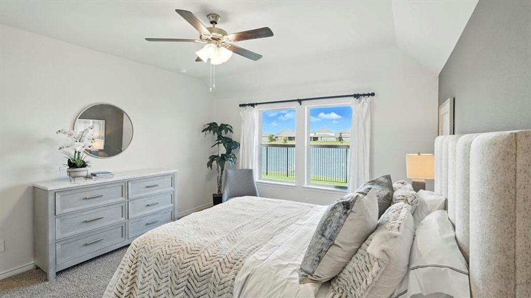 Bedroom featuring light colored carpet, ceiling fan, and vaulted ceiling