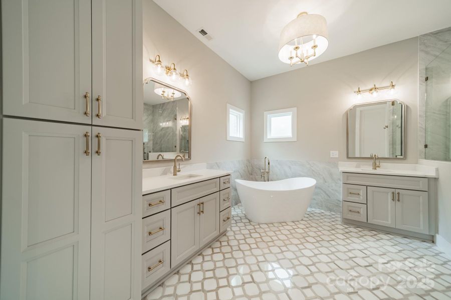 Your stunning Master Suite boasts beautiful custom lighting, cabinetry, tilework, a soaking tub, and a spacious shower.