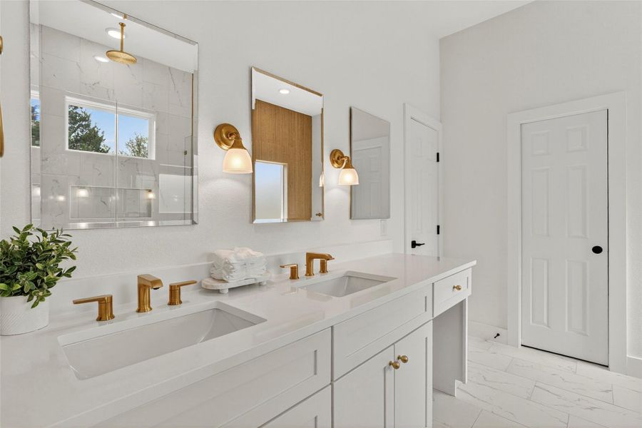 Full bathroom with double vanity, a marble finish shower, and light marble finish flooring
