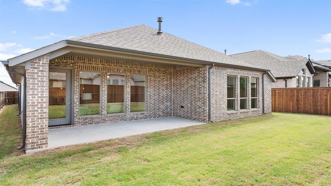 Back of house with a patio area and a lawn