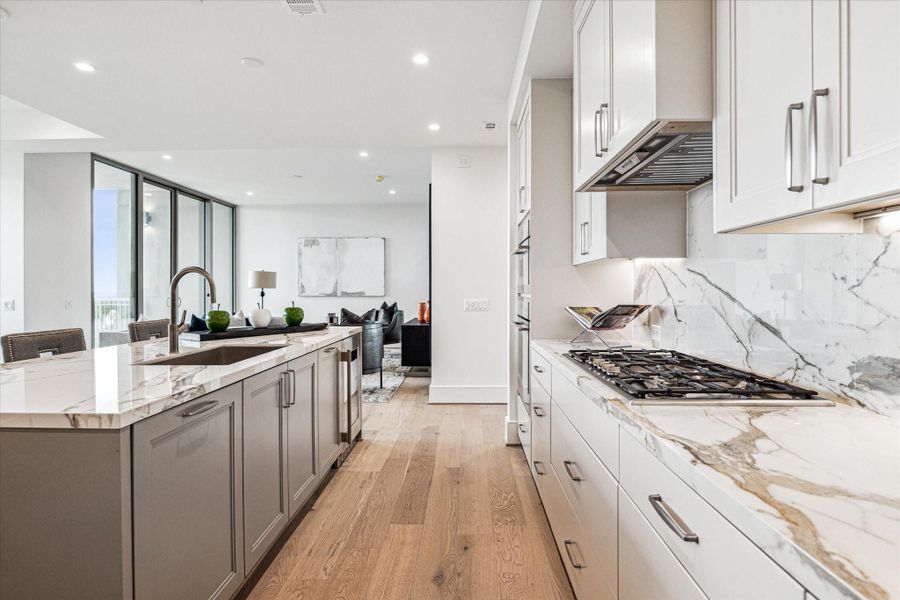 Stunning chef’s kitchen boasts sleek, modern design paired with top-of-the-line functionality. Photos are of a similar unit with the same floor plan