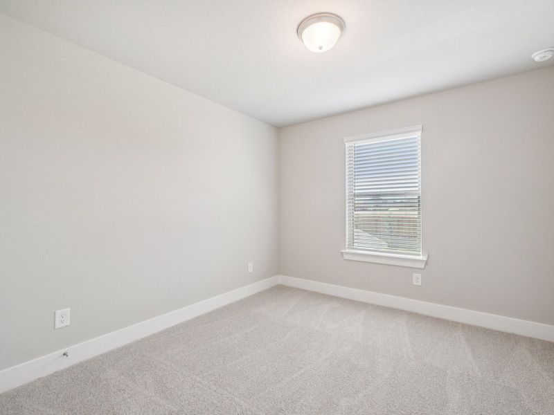 Guest bedroom in the Red River floorplan at a Meritage Homes community.