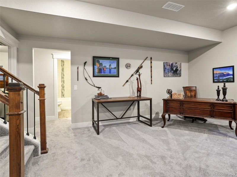 view of basement bath and hallway to two other bedrooms