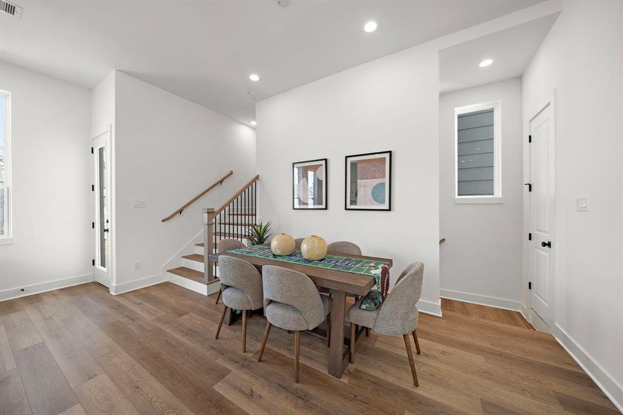 Bright and inviting dining area featuring elegant hardwood floors and modern lighting, perfect for intimate gatherings.