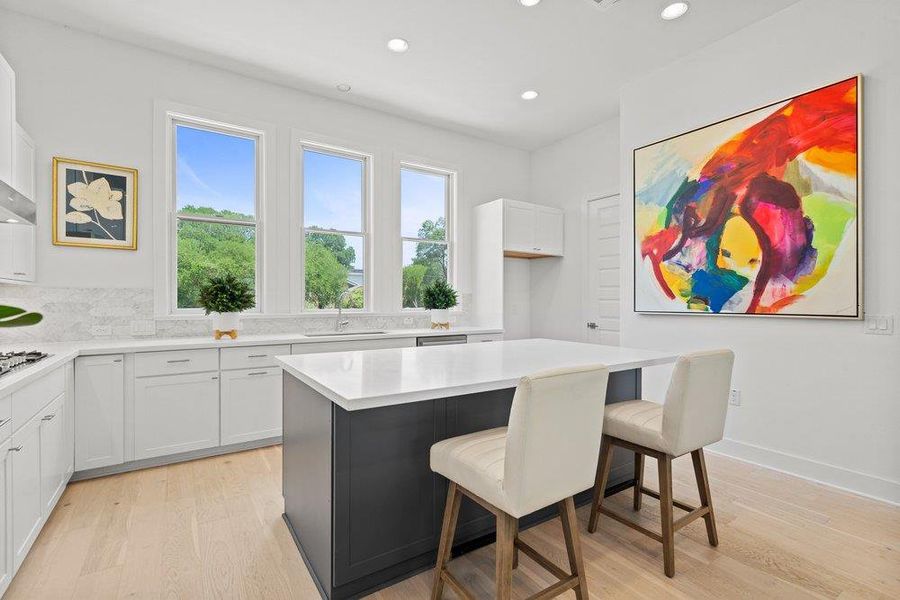Bright open kitchen showcasing a waterfall-edge island with seating.
