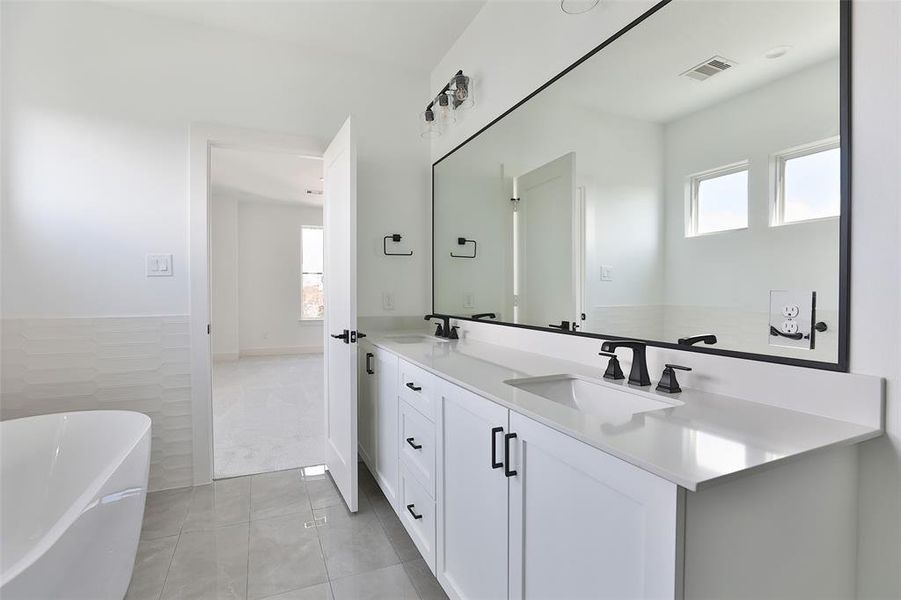 A double vanity with ample space to accommodate all your storage needs in the primary bathroom.