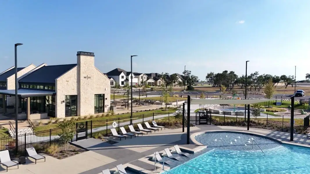 An inviting resort-style swimming pool neighbors the modern stone clubhouse facility.