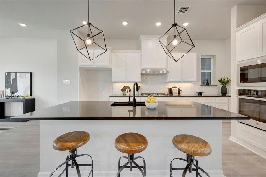 Expansive kitchen island with a dark countertop and integrated sink, complemented by white cabinetry