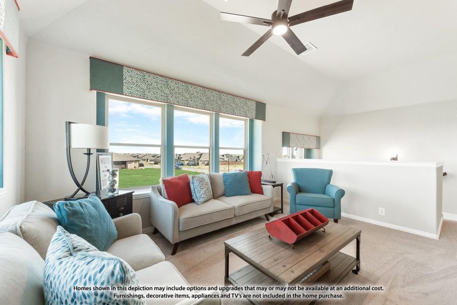 Living room with vaulted ceiling, ceiling fan, large windows, and neutral sofas with blue and red accent pillows Living room with vaulted ceiling, ceiling fan, large windows, and neutral sofas with blue and red accent pillows
