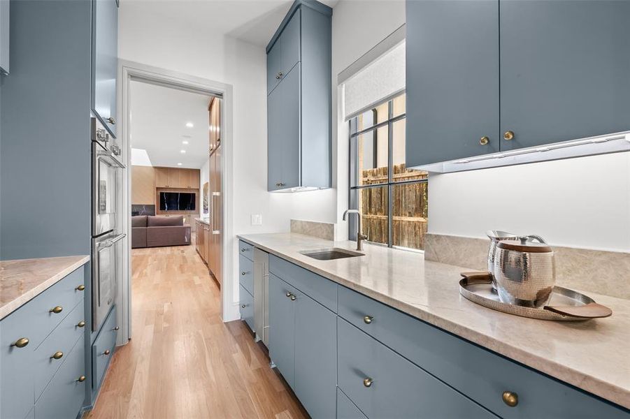 Butlers prep and storage pantry with double ovens, ice maker, sink, two refrigerated drawers, quartzite countertops