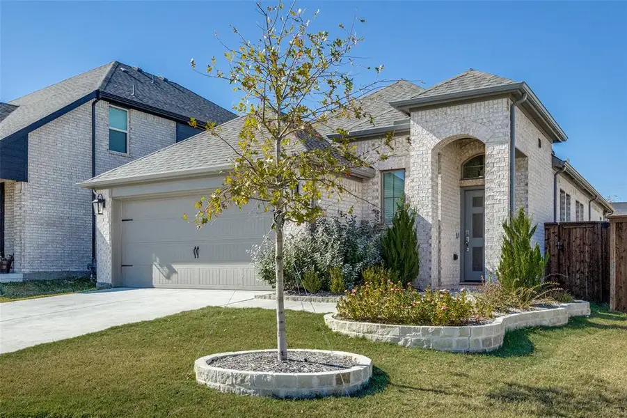 View of front of house with brick siding, a garage, and driveway