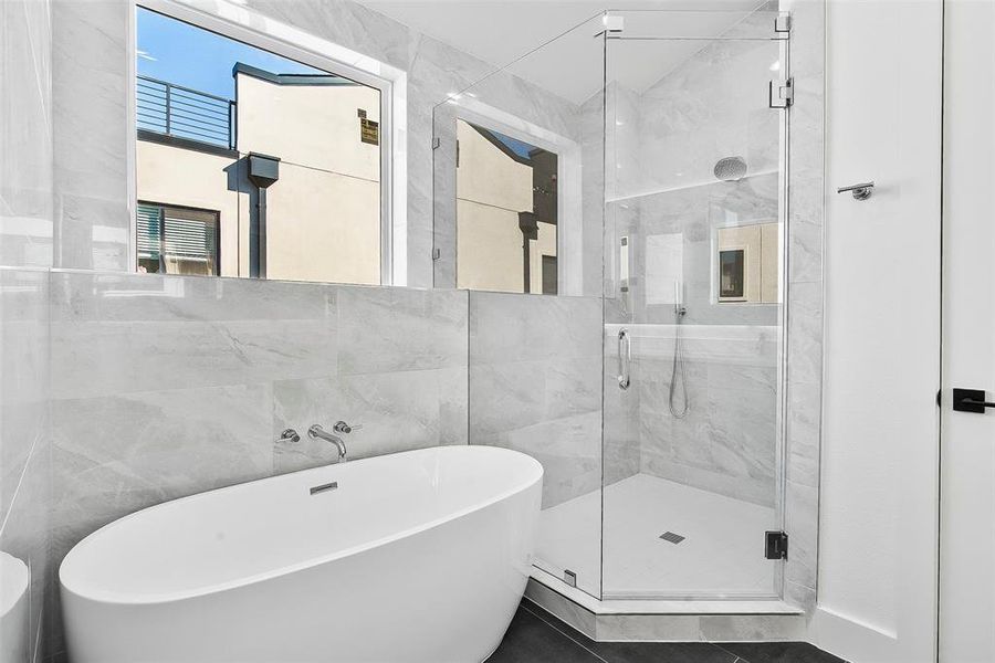 Bathroom featuring tile walls and independent shower and bath