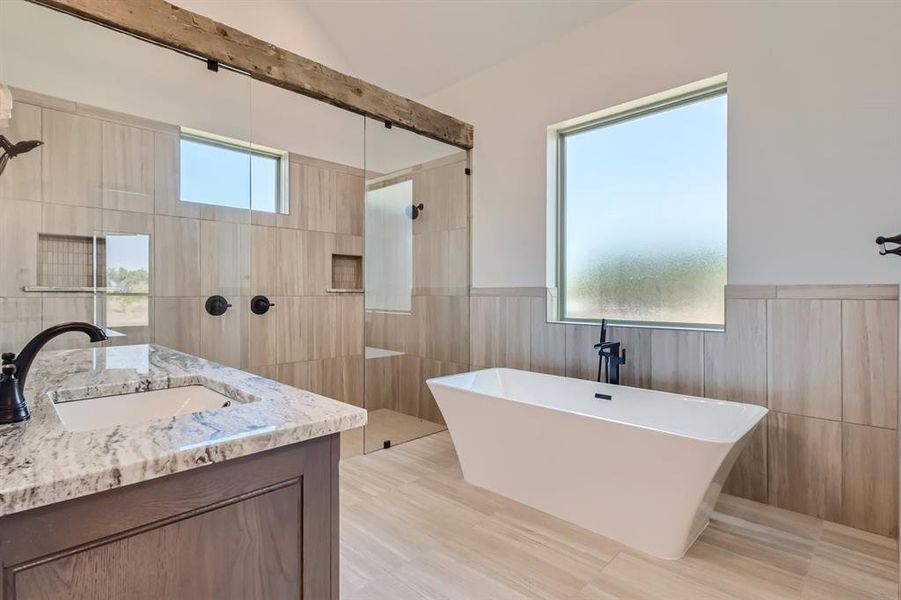 Bathroom featuring vanity, plus walk in shower, tile walls, and tile patterned flooring