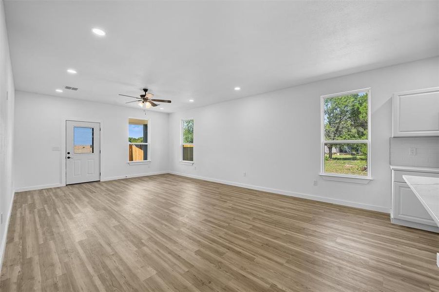 Unfurnished living room featuring recessed lighting, light wood-style flooring, and a ceiling fan Unfurnished living room featuring recessed lighting, light wood-style flooring, and a ceiling fan