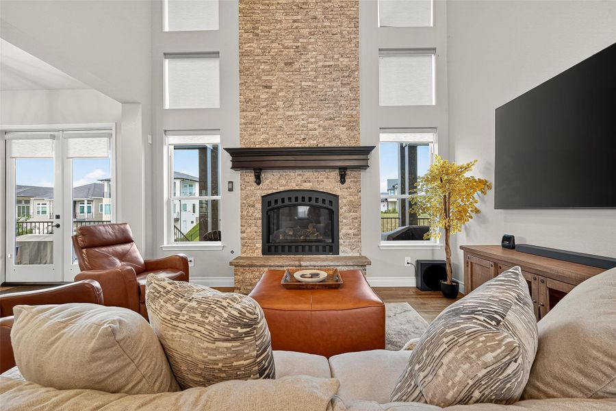 Stunning two-story living room with a floor-to-ceiling stacked-stone fireplace, soaring windows, and neutral color palette. Stunning two-story living room with a floor-to-ceiling stacked-stone fireplace, soaring windows, and neutral color palette.