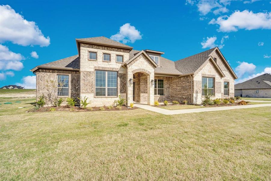Front exterior of a new home in Levante, Waxahachie, TX, highlighting curb appeal (Image 2). Front exterior of a new home in Levante, Waxahachie, TX, highlighting curb appeal (Image 2).