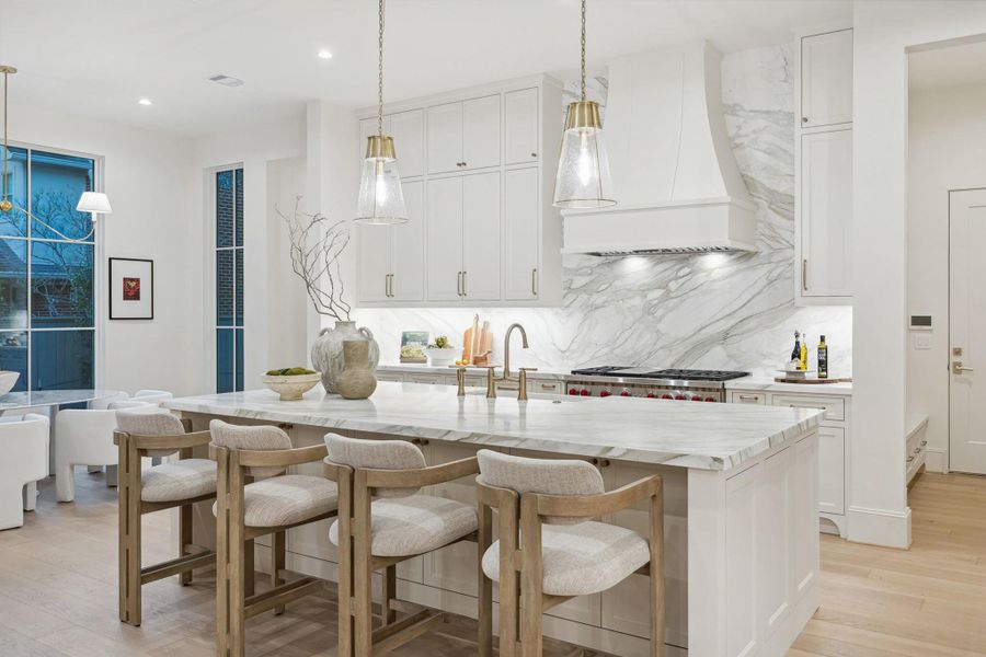 The kitchen showstopper is the expansive marble island with seating, complemented by custom cabinetry. Has a high-CFM vent hood with dedicated make-up air system. Introduces fresh air when the range hood is running, helping maintain balanced air pressure and proper ventilation The kitchen showstopper is the expansive marble island with seating, complemented by custom cabinetry. Has a high-CFM vent hood with dedicated make-up air system. Introduces fresh air when the range hood is running, helping maintain balanced air pressure and proper ventilation