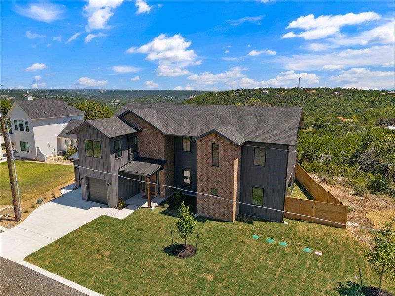 View of front facade featuring concrete driveway, board and batten siding, a garage, and brick siding