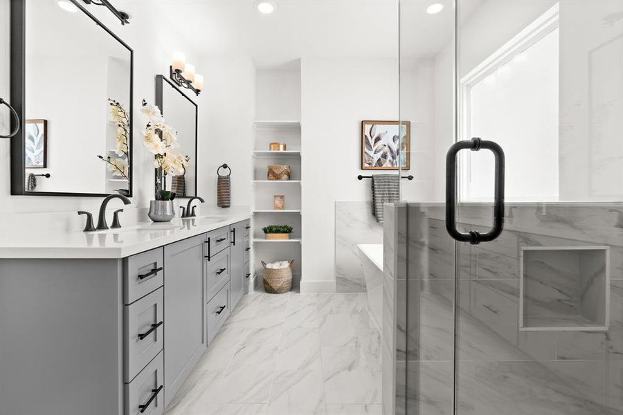 A breathtaking view of the primary bathroom with frameless shower and stand alone tub with accent shelves.