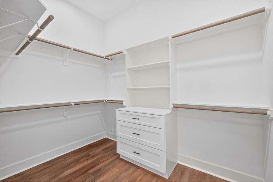 Large walk-in closet with custom built-in cabinetry and organized storage solutions. Large walk-in closet with custom built-in cabinetry and organized storage solutions.