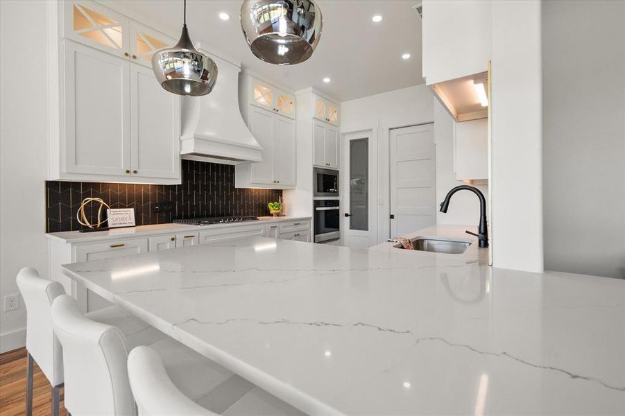 Gorgeous Quartz counters with modern pendant lighting