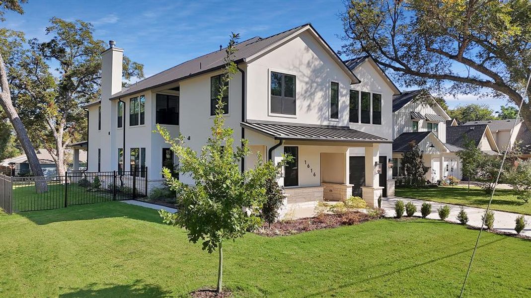 View of front facade with a standing seam roof, a metal roof, a porch, a chimney, and stucco siding View of front facade with a standing seam roof, a metal roof, a porch, a chimney, and stucco siding