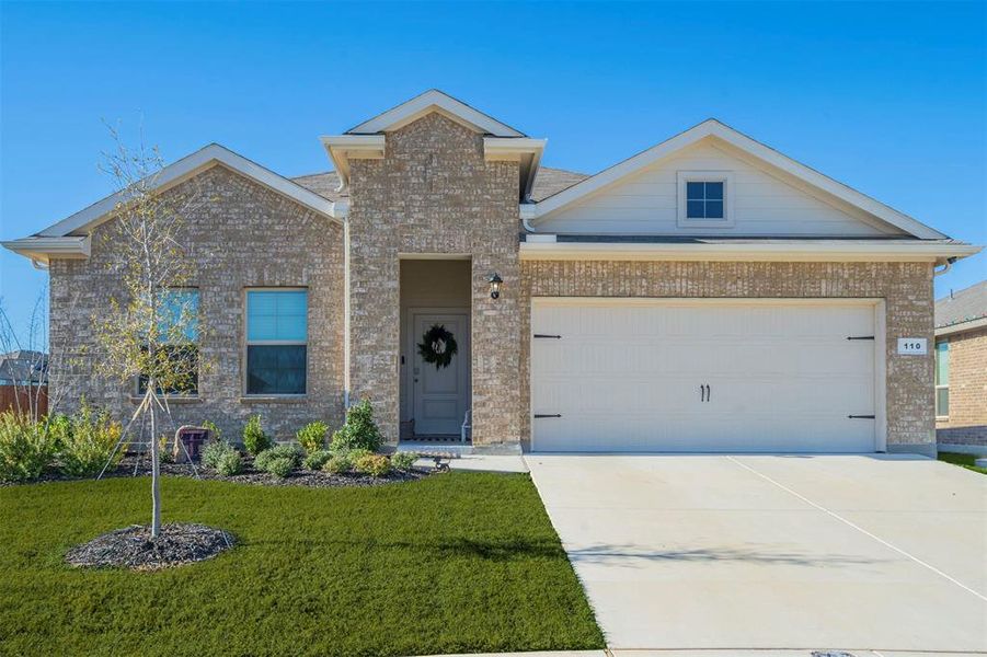 View of front of house with a garage and a front lawn