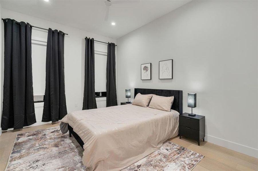 Bedroom featuring recessed lighting, light wood-type flooring, and a ceiling fan Bedroom featuring recessed lighting, light wood-type flooring, and a ceiling fan