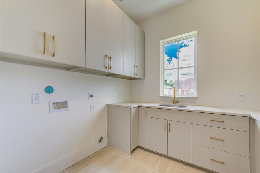 Conveniently located on the second floor near the secondary bedrooms, the well-appointed laundry room combines everyday functionality with elevated design. Custom designer cabinetry provides exceptional storage while beautiful quartzite countertops offer generous workspace for folding, sorting, and organization. A large utility sink, abundant storage solutions, and natural light create a bright, efficient space that transforms a daily necessity into a thoughtfully designed extension of the home's luxury fin