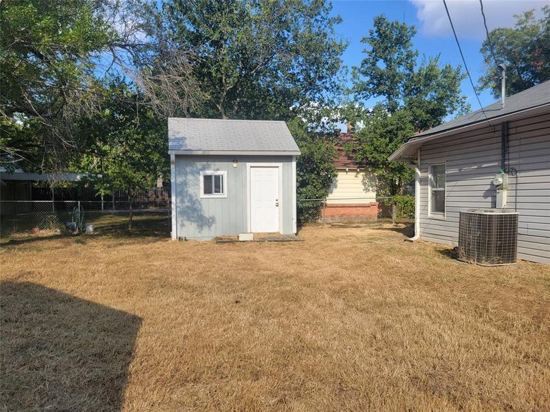 View of yard featuring central air condition unit and a shed