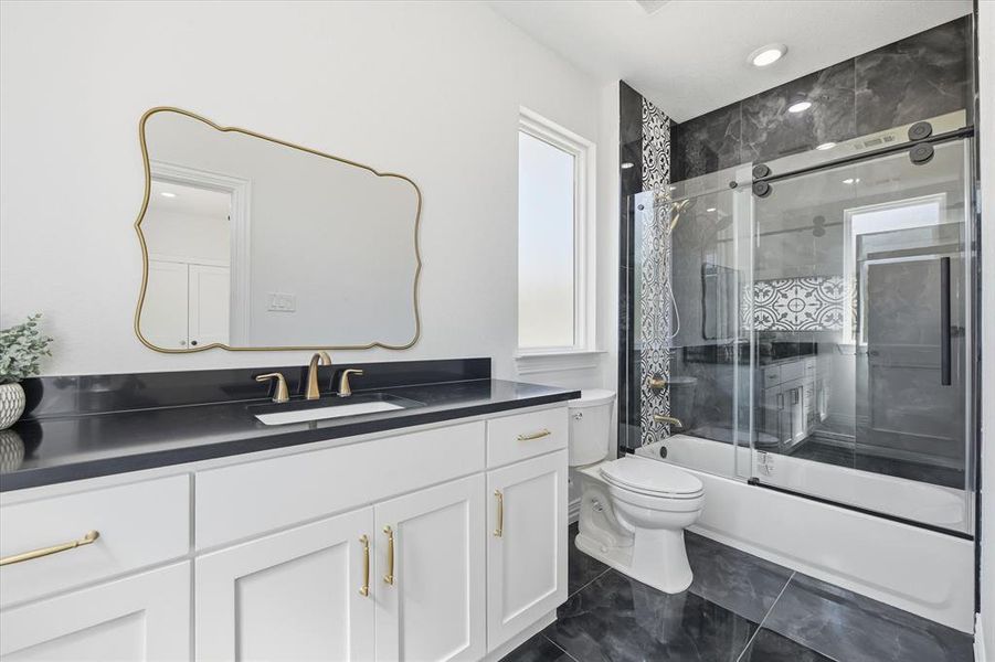 Bathroom with vanity and bath / shower combo with glass door