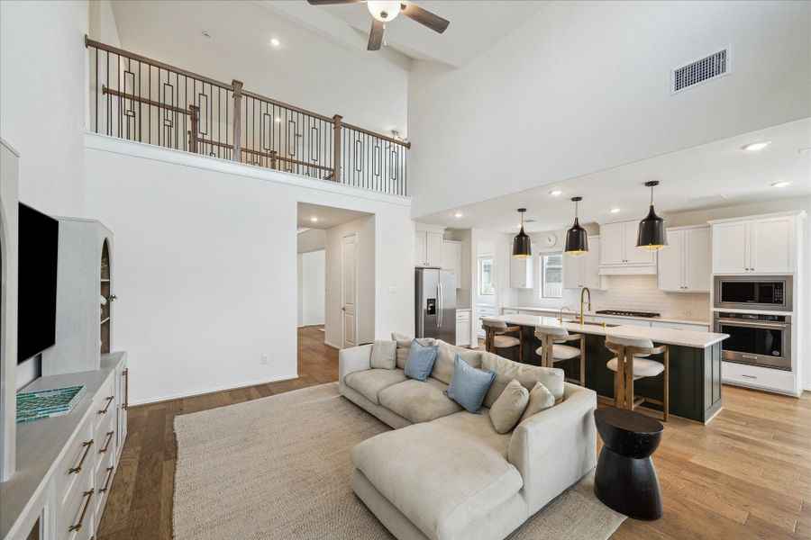 An additional view of the family room reveals the lofted hallway above, offering a scenic overlook of the main living area and enhancing the home’s open, connected feel.