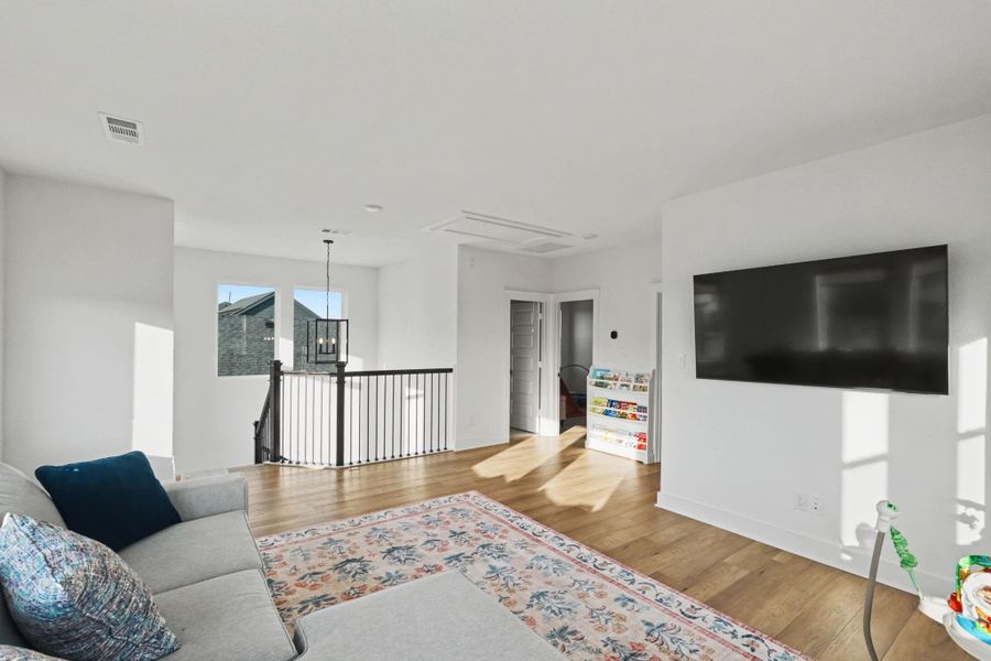 Generous upper-level living space with open railing views and abundant sunlight. Ideal as a media room, game room, or lounge, this flexible area offers comfortable separation from the main living spaces.