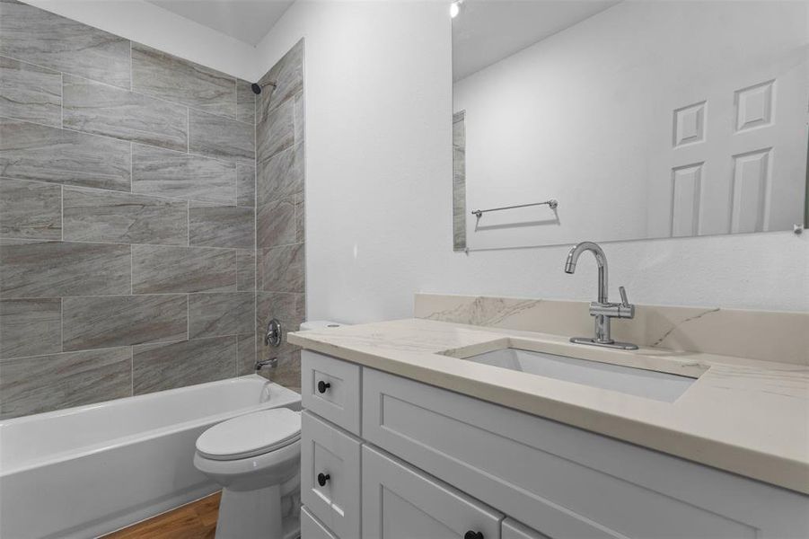 Full bath featuring bathing tub / shower combination, vanity, and wood finished floors