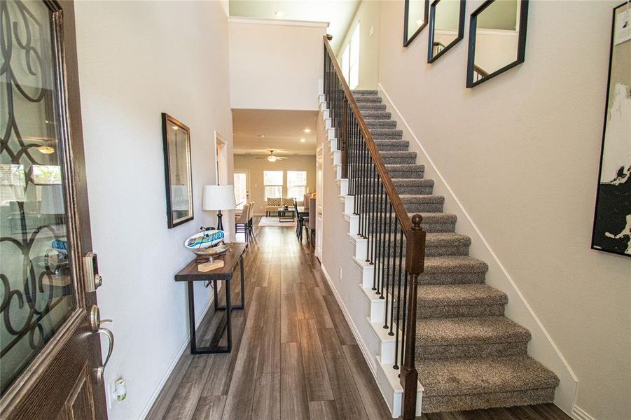 Entrance foyer featuring dark wood-style floors, stairway, a high ceiling, and recessed lighting Entrance foyer featuring dark wood-style floors, stairway, a high ceiling, and recessed lighting