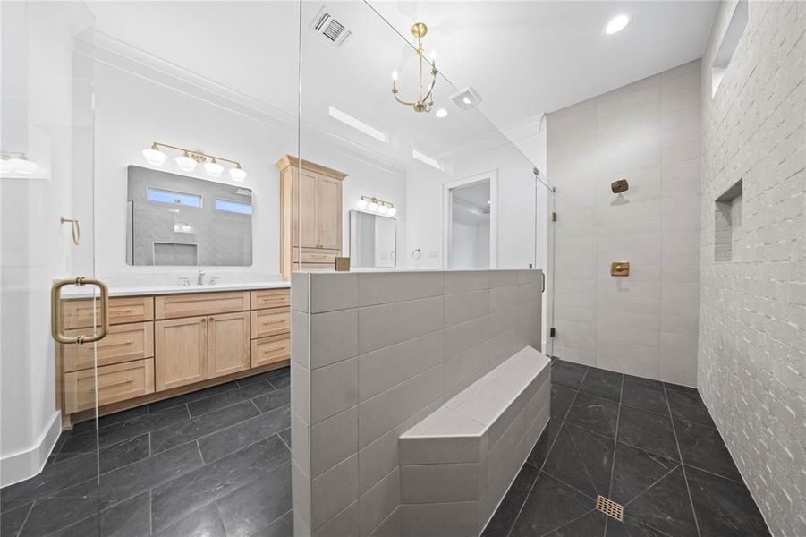Full bathroom with tiled shower, vanity, ornamental molding, tile patterned flooring, and tile walls
